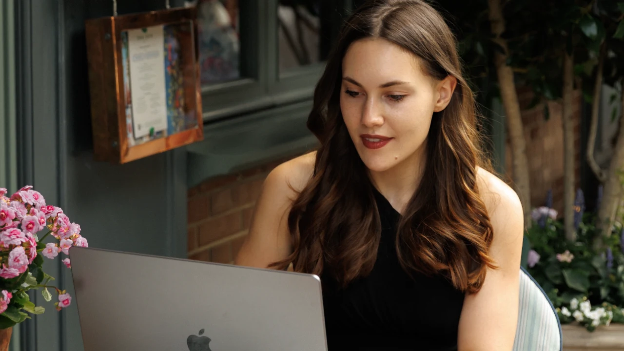 Lina working on her laptop at an outdoor café